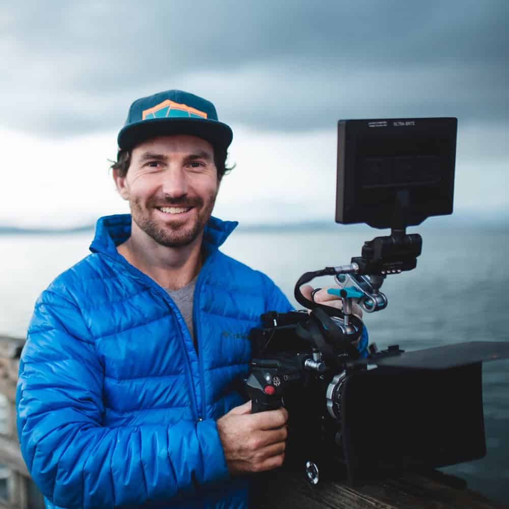 Marc Rotse, founder of Lightbox Filmworks, holding a cinema camera during a documentary film production shoot outdoors